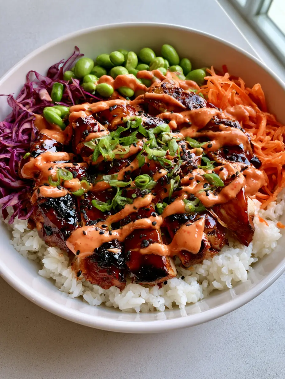 Korean BBQ Chicken Bowls with Creamy Gochujang Mayo 4 A white ceramic bowl filled with steamed white rice, caramelized chicken, shredded carrots, and red cabbage (Korean BBQ Chicken Bowls).