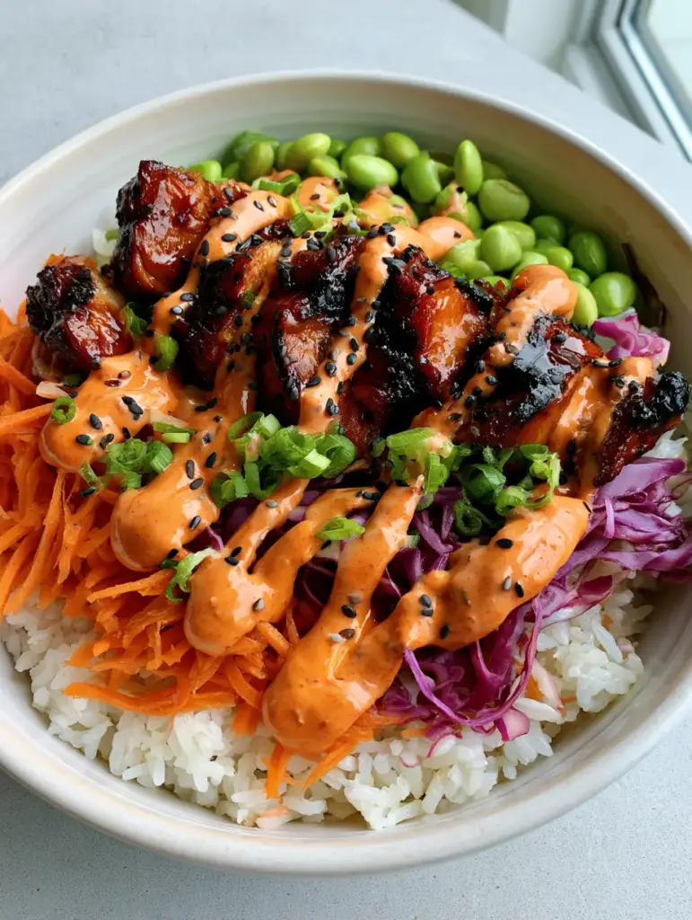 Korean BBQ Chicken Bowls with Creamy Gochujang Mayo 1 A handheld smartphone photo of Korean BBQ Chicken Bowls with a thick zig-zag of gochujang mayo sauce.
