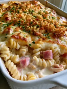 Close up shot of Chicken Cordon Bleu Casserole showing the thick velvety cream sauce and bubbly golden Swiss cheese topping.