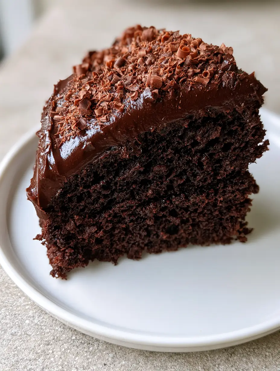 Midnight Chocolate Fudge Cake: The Ultimate Moist Dark Chocolate Sponge 3 A single slice of deep dark chocolate sponge cake with visible aeration and glossy dark chocolate fudge frosting. (Midnight Chocolate Fudge Cake)